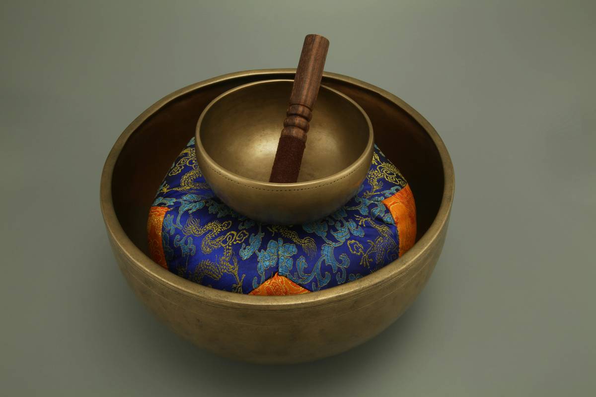A bowl of turmeric powder next to fresh roots